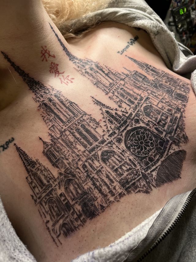 Fine line cathedral spires and a rose window spread across the upper chest.