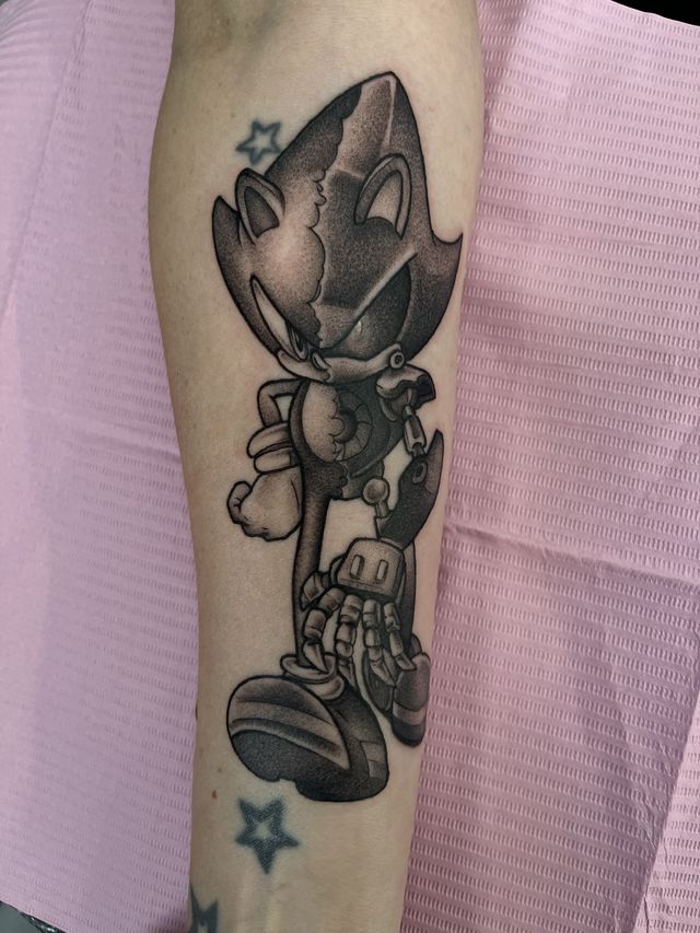 Black and grey robot hedgehog video game character on a forearm.